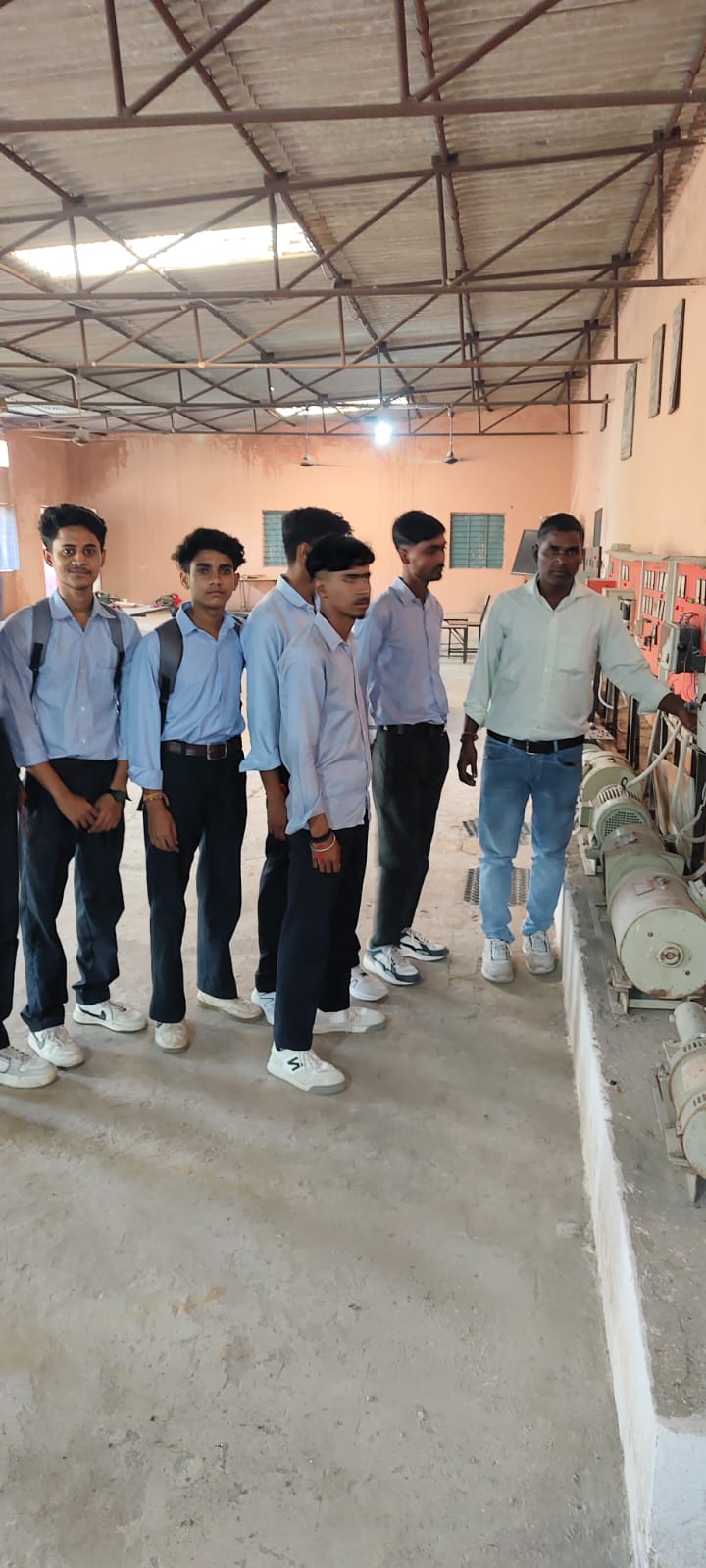 Practical class &mdash; trainees with their instructor at the motors and control panels
